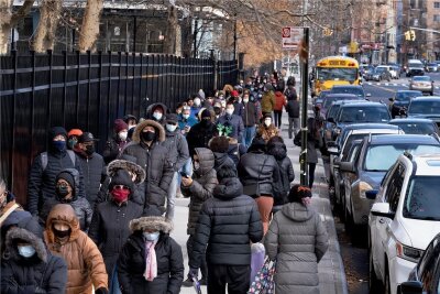 Corona in den USA: Die Omikron-Explosion - Eine lange Menschenschlange steht auf einem Gehweg im New Yorker Stadtbezirk Manhattan nach Coronatestkits an. 