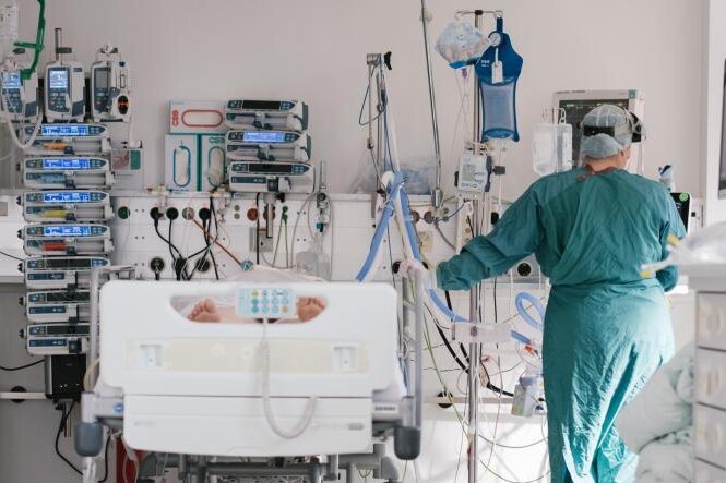 Corona in Sachsen: Noch 20 Kommunen über Inzidenz von 500 - Eine Pflegerin versorgt auf einer Intensivstation einen an Covid-19 erkrankten Patienten. 