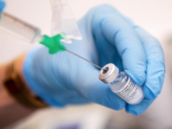            Eine Klinik-Mitarbeiterin zieht den Covid-19 Impfstoff für eine Impfung auf eine Spritze.