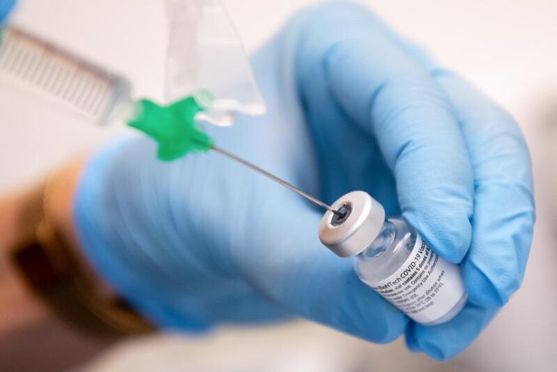            Eine Klinik-Mitarbeiterin zieht den Covid-19 Impfstoff für eine Impfung auf eine Spritze.