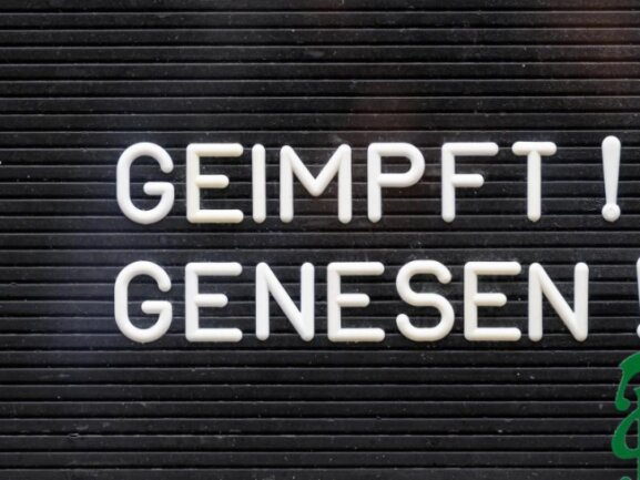            «Geimpft! Genesen!» steht auf einem Schild an einer Bar.