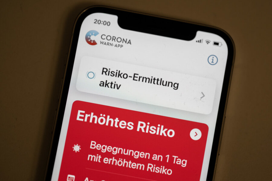 Eine Corona-Warn-App zeigt auf einem Handy ein erhöhtes Risiko an, mit einer an Corona infizierten Person Kontakt gehabt zu haben. 