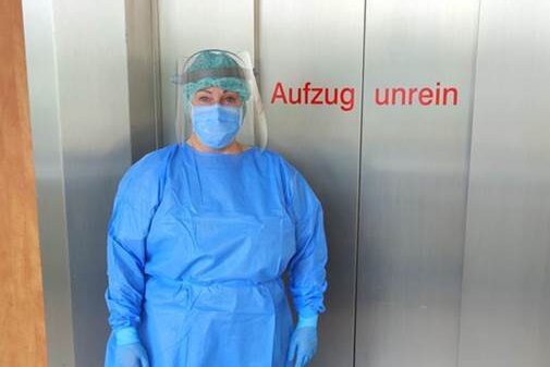 Eine Stationsschwester in voller Schutzkleidung des Kreiskrankenhauses Stollberg vor einem Patientenaufzug, welcher als "unrein" definiert ist und nur für Covid-19-Patienten in Betrieb genommen wird. 