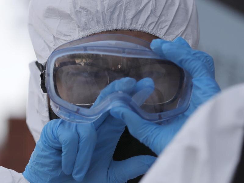 Coronavirus: Sachsen verzeichnet bislang höchsten Anstieg bei Infektionen - 25 Tote -             Person in Schutzkleidung.