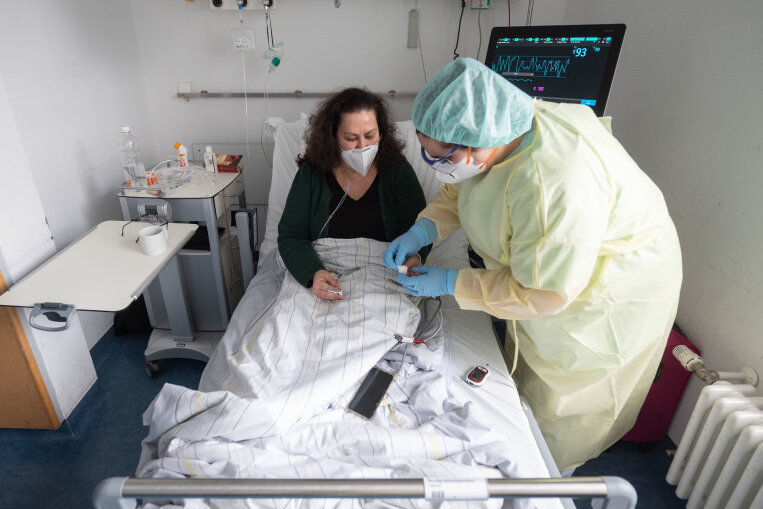 Tena Bogdanovic, Krankenpflegerin, misst in einem Patientenzimmer einer Covid-19-Station im Klinikum Stuttgart den Blutzucker der Patientin Ioanna Maag-Nikolopoulou. Es ist ein neues Phänomen: Die Corona-Pandemie verlagert sich stärker auf die Normalstationen der Krankenhäuser. Denn bei vielen Patienten wird das Virus zur Nebendiagnose.