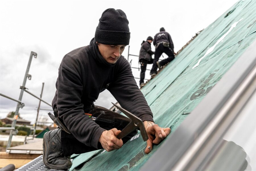 Dachdeckermeister aus dem Vogtland beklagen Bürokratie: „90 Prozent der Arbeitszeit am Schreibtisch“ - Dachdecker Ronny Anger befestigt auf einer Baustelle in Falkenstein die erste Dachhaut.