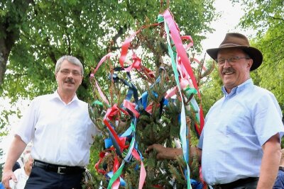 Darum fällt zum Abschied des Bürgermeisters in Johanngeorgenstadt ein Maibaum - Konrad Fenzl (rechts) übergibt die Spitze des Maibaums an Holger Hascheck, dessen Bürgermeister-Zeit am 31. Jul endete. 
