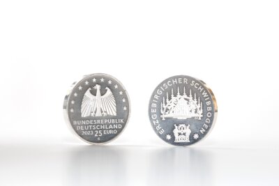 Das Erzgebirge hat seine eigene Münze: Ein Schwibbogen ziert die neue deutsche 25-Euro-Silbermünze - So sieht die Schwibbogen-Münze aus.