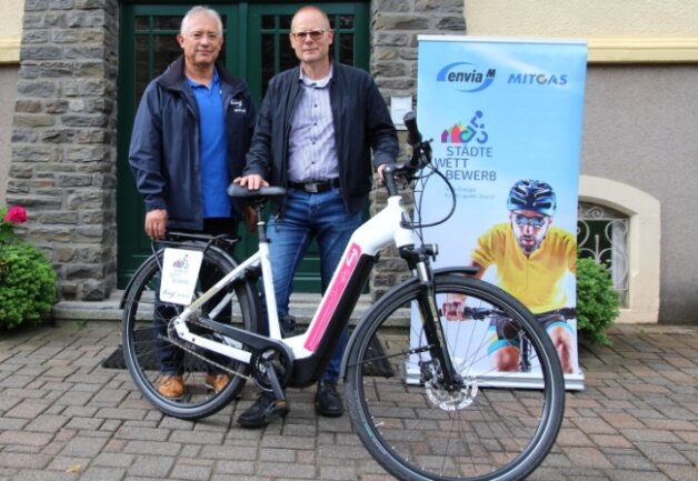 Das Kartoffelfest wird sportlich - Bürgermeister Axel Röthling (re.) hat diese Woche von Jürgen Lojewski (Envia M) ein E-Bike erhalten, um darauf 100 Kilometer zu absolvieren. 
