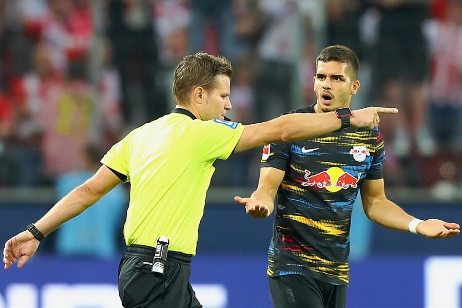 Schiedsrichter Felix Brych zeigt nach Videobeweis auf Tor für Köln, RB-Stürmer André Silva kann es nicht fassen. 