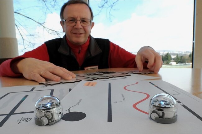 Michael Schwan, Leiter der Awo-Schullandheime Vogtland, mit zwei der neuen Miniroboter und vorgedruckten Parcours. 