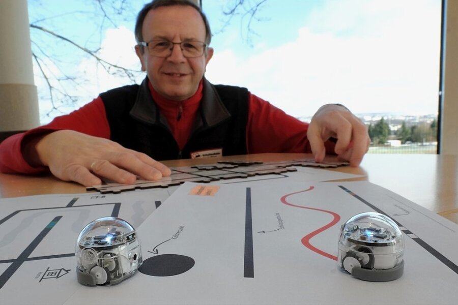 Michael Schwan, Leiter der Awo-Schullandheime Vogtland, mit zwei der neuen Miniroboter und vorgedruckten Parcours. 