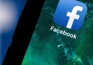 Datenschutz: Staatsregierung klagt gegen Facebook-Verbot - Auf dem Bildschirm eines Smartphones sieht man das Logo von Facebook.