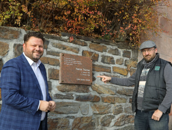 Der Meeraner Stadtrat Udo Friedrich (rechts) an der Metall-Gedenkplatte für Patrick Thürmer, die nun gestohlen wurde. 