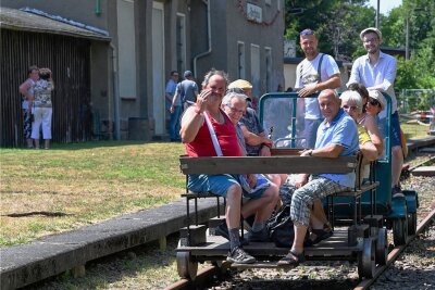 Der Eisenbahn-Narr vom Oberfrohnaer Bahnhof - Bürgermeister Robert Volkmann (hinten rechts) und Toni Naumann von den Muldentalbahn-Freunden kutschieren Gäste auf der Draisine. 