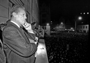 Ein nachdenklicher Willy Brandt vor Tausenden Menschen auf dem Balkon des Zwickauer Rathauses am 25. Februar 1990.