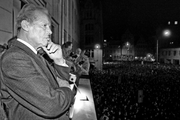 Ein nachdenklicher Willy Brandt vor Tausenden Menschen auf dem Balkon des Zwickauer Rathauses am 25. Februar 1990.