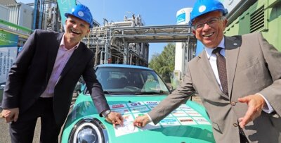 Der neue Kraftstoffprofessor auf der Reichen Zeche - Prof. Martin Gräbner (l.) und Prof. Klaus-Dieter Barbknecht, Rektor der TU Bergakademie Freiberg, verewigen das Logo der Ressourcenuniversität auf dem e-Fuels-Fahrzeug.