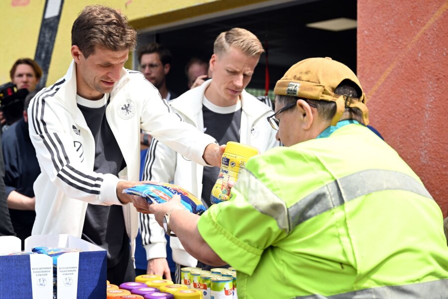 DFB-Stars Müller und Führich verteilen Lebensmittel - Die Nationalspieler Thomas Müller (l) und Chris Führich geben bei der Blankenhainer Tafel Essen aus.