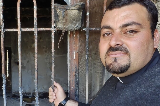 Priester Madschid vor seinem Haus: Die Terrormiliz IS hat mehr als die Hälfte der Gebäude in der Christen-Hochburg Karakosch zerstört.