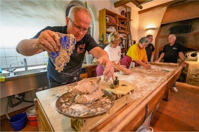 Die Brot-Enthusiasten: Endlich wieder Schaubacken in Bad Schlema - Stephan Lamm (vorn) portioniert den Teig für die Brote. Jeweils 850 Gramm hat so ein Teigling, bevor er in den Ofen geschoben wird. Nach dem Backen sind es noch um die 750 Gramm.
