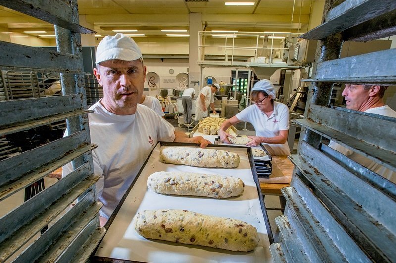 Die ersten Stollen sind schon fertig - Kay Blaschke ist einer der Bäcker, die aus dem Teig per Hand Stollen formen. Mehr als 100 Stück gehen pro Stunde durch seine Hände.
