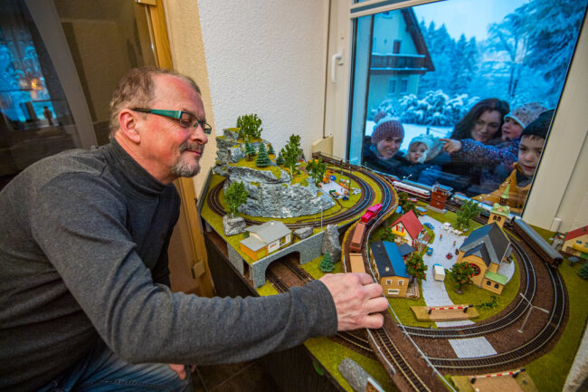 Die Erzgebirger haben es eben drauf: Dieser Zug verkehrt ab "Bahnhof Stubenfenster" - Thomas Uhlmann mit seiner Eisenbahnahn und Zuschauern vor dem Stubenfenster in der Forststraße 9: Franziska Wittstock mit Friederike sowie Kristin Wittstock mit Hilda und Hannes (von links nach rechts). 