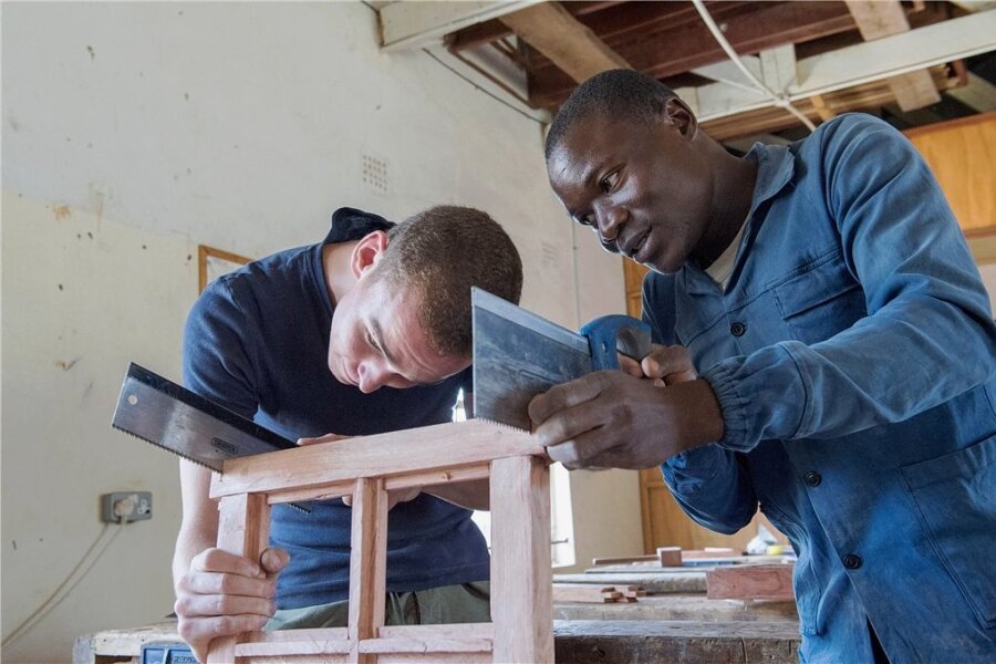Die Freiwilligenfalle - Gemeinsam sägt es sich schneller: David Horch (li.) arbeitet als Freiwilliger im Städtchen Choma in Sambia. Dort engagiert er sich im Chodort Training Centre, einer Weiterbildungseinrichtung der United Church of Zambia.