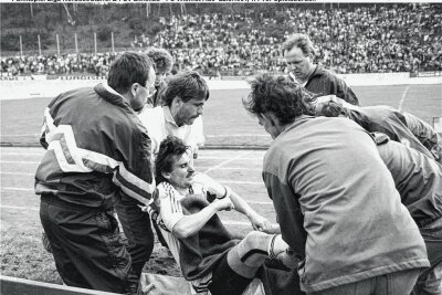 Die Fußball-Randale 1991 in Zwickau: Wie der Fotograf Frank Kruczynski sie erlebte - Der Auer Spieler Michael Gessner (Mitte) wird verletzt auf eine Trage gehoben. 
