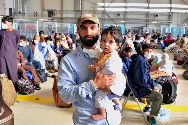 Die Glückssucher von Ramstein - Tausende evakuierte Afghanen warten auf Ausreise - Zubair Hakimi mit seiner elfmonatigen Tochter Usra in einer Halle auf der US-Luftwaffenbasis im pfälzischen Ramstein. Der 26-Jährige hat auf der Nato-Basis in Kabul als Techniker für die Amerikaner gearbeitet. Er gehört zu den tausenden Afghanen, welche nach Deutschland ausgeflogen wurden und nun auf ihren Weiterflug in die USA und andere Länder warten. 