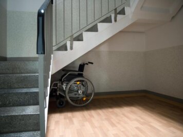 Die graue Wohnungsnot: Mehr Senioren als Wohnungen im Erzgebirgskreis - Ein Rollstuhl steht unter einer Treppe in einem Wohnhaus in Sachsen.