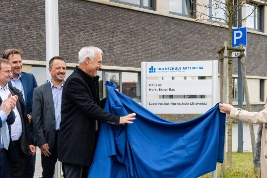 Die Laser-Exzellenz hat jetzt einen Namen - Horst Exner (Bildmitte) enthüllt den neuen Namen des Forschungsbaus am Laserinstitut Hochschule Mittweida. 