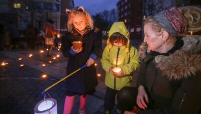 "Die Not der Jüngeren ist in der Pandemie gewachsen" - Karoline Bartel und ihre Kindern Johanna und Bjarne stellen vor dem Bürgerzentrum Kerzen auf. Die Lichter ergeben das Wort "Gemeinsam". 