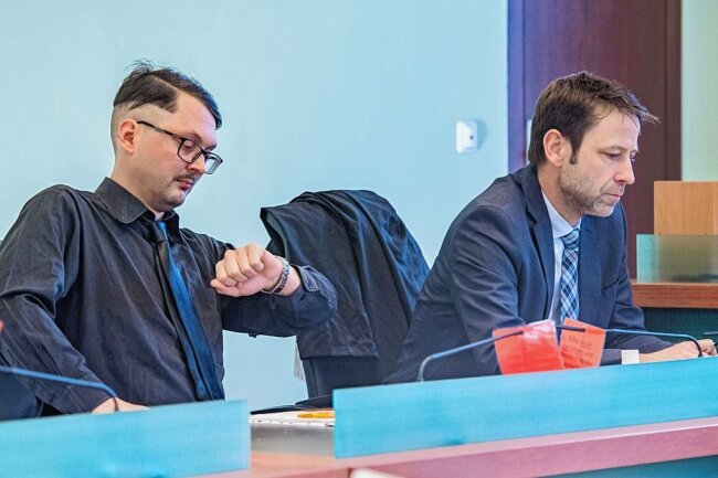 "Die Partei"-Landeschef in Aue vor Gericht: Hakenkreuz-Prozess endet mit Freispruch - Der Landesvorsitzende der Satirepartei "Die Partei" in Sachsen, Tom Rodig, wartet mit seinem Anwalt Axel Kaufmann auf der Anklagebank im Amtsgericht Aue auf seinen Prozess. 