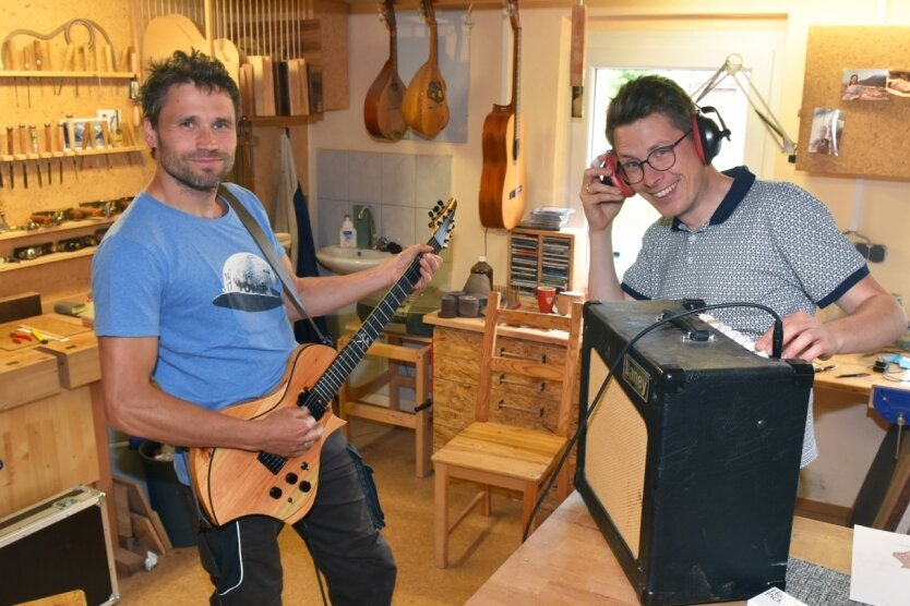 Roy Fankhänel (links) aus Oelsnitz und Tim Walter aus Burgstädt haben die Gitarrenmanufaktur Odem gegründet. Mit dem neuen Teil wird schon mal in der Werkstatt abgerockt. 