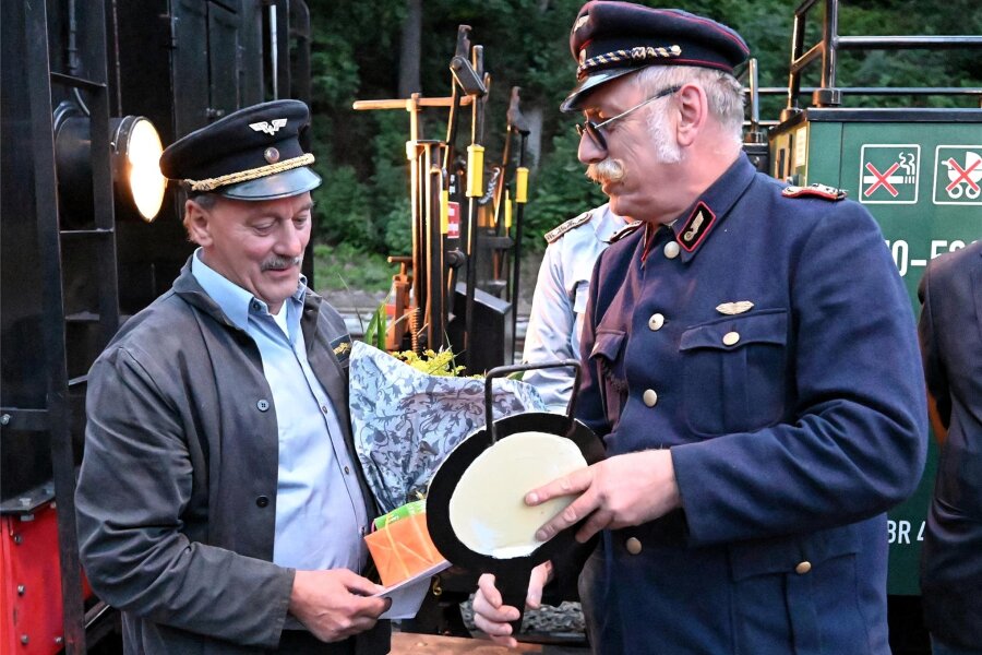 Dienstältester Lokführer der Fichtelbergbahn dampft in den Ruhestand - Lokführerkollege Wilko Schulz (rechts) übergibt zum Abschied eine symbolische Schlussscheibe.