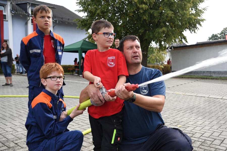 Diese zwei Kameraden geben vollen Einsatz für den Feuerwehrnachwuchs in Tirpersdorf - Dirk Maiwald (rechts) von der freiwilligen Feuerwehr in Tirpersdorf bei einer Spritzübung mit Kindern aus dem Nachwuchsbereich der Feuerwehr.