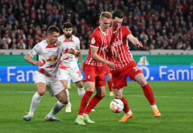 Die Freiburger Michael Gregoritsch (r) und Philipp Lienhart kämpfen mit Leipzigs Willi Orban (l) um den Ball. 