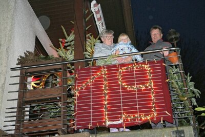 Dorf im Vogtland präsentiert sich über Weihnachten als riesiger Adventskalender - Jürgen und Bärbel Angermann - auf dem Bild mit Enkelin Mia - haben die 19 beim Adventskalender gestaltet. Ihre Zahl sowie alle anderen werden nochmals gemeinsam am 25. und 26. Dezember leuchten.