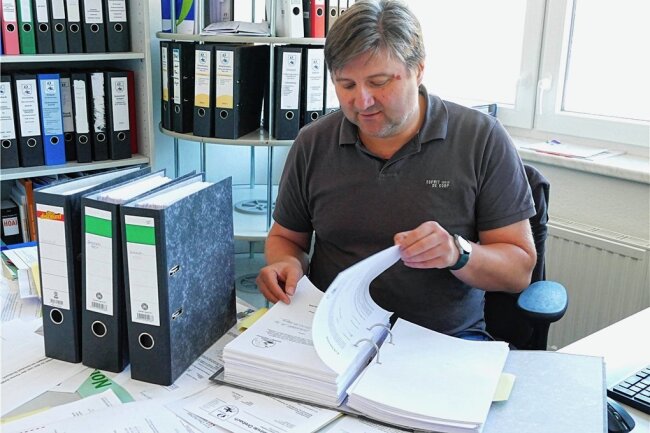 Drebach: 1800 Unterschriften gegen Windpark-Plan - In der Drebacher Bauverwaltung wirft Thomas Berger einen Blick auf die vier Ordner umfassende Unterschriftensammlung der Windpark-Gegner, die demnächst an das Landratsamt weitergereicht wird. 