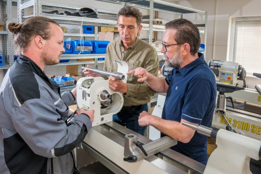 Robin Leonhardt bespricht mit Roland und Martin Steinert (v. l.) bei der Montage einer Drechselbank ein technisches Detail. 