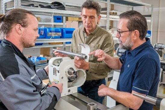 Drechselzentrum Erzgebirge expandiert - Robin Leonhardt bespricht mit Roland und Martin Steinert (v. l.) bei der Montage einer Drechselbank ein technisches Detail. 