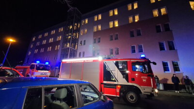 Dritter Brand in vier Tagen in Plauener Wohnblock: Polizei ermittelt wegen schwerer Brandstiftung - Erneut sind am Freitagabend Rettungskräfte zum Wohnblock im Mammengebiet gerufen worden. Viele Bewohner versammelten sich im Freien.