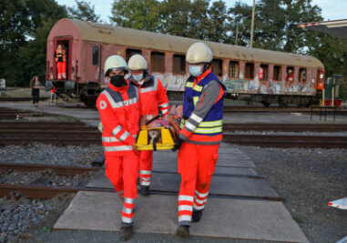 DRK-Helfer proben Ernstfall: Zugunglück am Bahnhof Glauchau simuliert - Helfer bringen bei der Übung eine verletzte Person aus dem Eisenbahnwagen. 