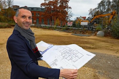 DRK investiert in Werdauer Brache: Anfang Mai ist Baustart für Sechs-Millionen-Objekt - Lars Kretzschmar auf dem künftigen Standort des Neukomplexes in der Werdauer Innenstadt mit den Bauplänen. 