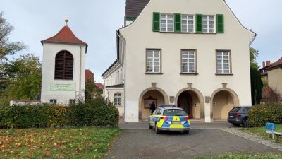 Leipzig: Ein Polizeiauto steht am Sonntag vor einer Kirche. Eine Drohung gegen eine Kirche in Leipzig hat in der Nacht zu Sonntag einen Großeinsatz der Polizei ausgelöst.