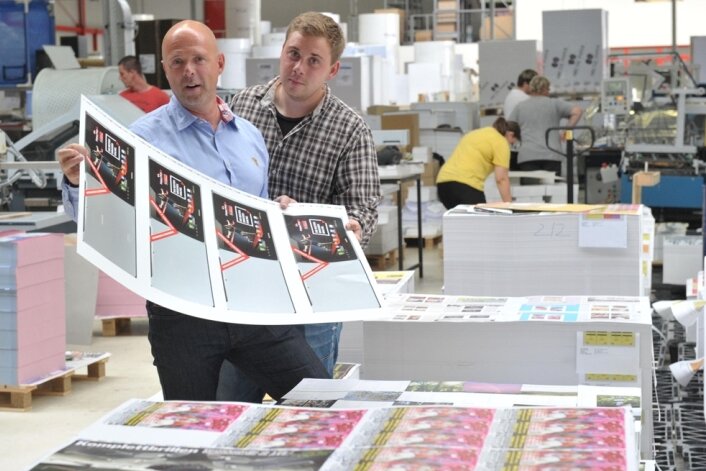 Druckerei investiert 10 Millionen Euro in neues Werk in Grossschirma - Geschäftsführer Torsten Zech (l.) und sein Sohn Maximilian Zech kontrollieren an einer Stapelmaschine die Ausdrucke.