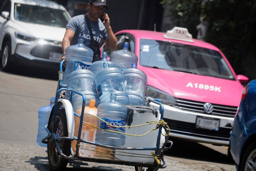 Dutzende Todesfälle wegen extremer Hitze in Mexiko - Ein Mann geht mit leeren Wasserkanistern durch eine Straße in Mexiko-Stadt. In 27 der 32 Bundesstaaten in Mexiko liegen die Temperaturen bei mehr als 40 Grad.