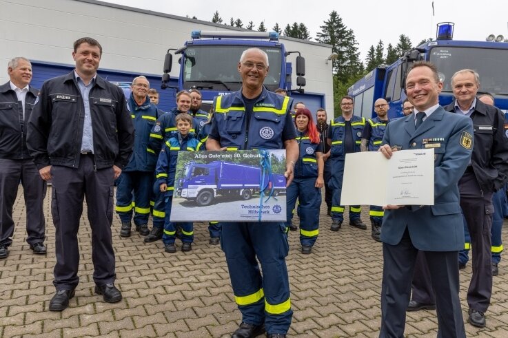 Überraschung geglückt: Viele Kameraden des Ortsverbands Annaberg des Technischen Hilfswerks waren dabei, als Klaus Hauschild (Mitte) aus Anlass seines 80. Geburtstags von Sven Hoppe (rechts), dem Leiter der TWH-Regionalstelle Chemnitz, geehrt wurde. 