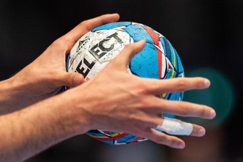            Ein Handballer hält einen Handball in den Händen.